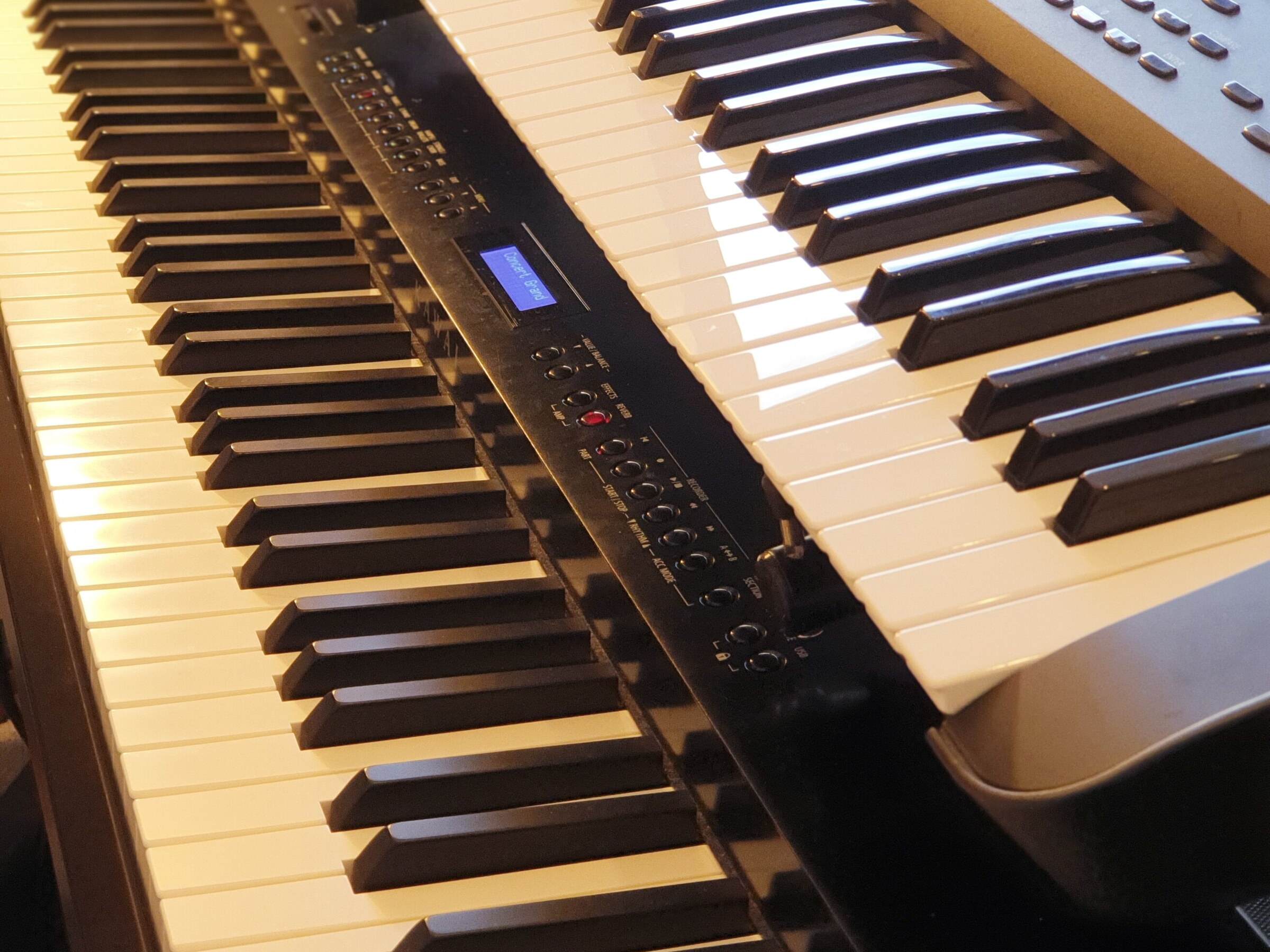 Zwei Digiale Pianos übereinander: Oben liegt ein kleineres Keyboard, unten ein Stagepiano mit 88 Tasten und Hammermechanik.