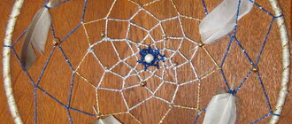 Ein selbstgebastelter Traumfänger mit Glitzerfäden, Perlen und Federn