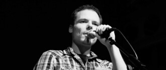 Ein schwarzweiß-Fotografie von mir mit Mikrofon während eines Auftritts