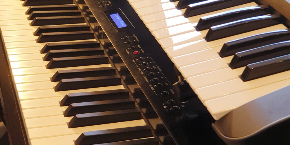 Zwei Digiale Pianos übereinander: Oben liegt ein kleineres Keyboard, unten ein Stagepiano mit 88 Tasten und Hammermechanik.